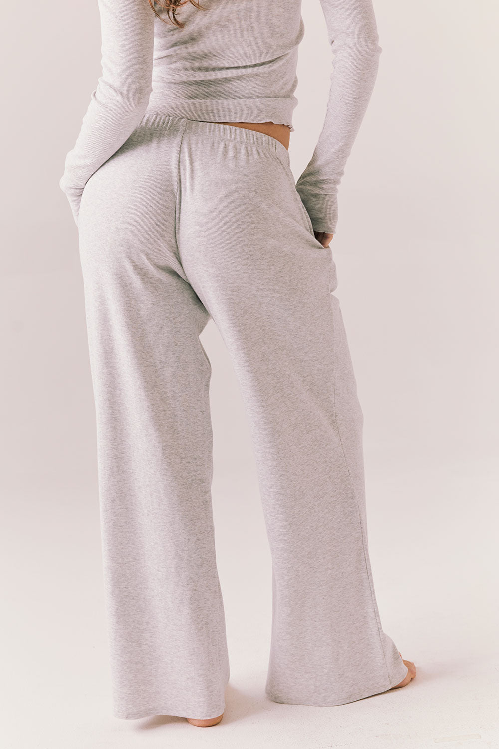 Light heather grey joggers with elastic waistband and relaxed fit, made from recycled fleece.