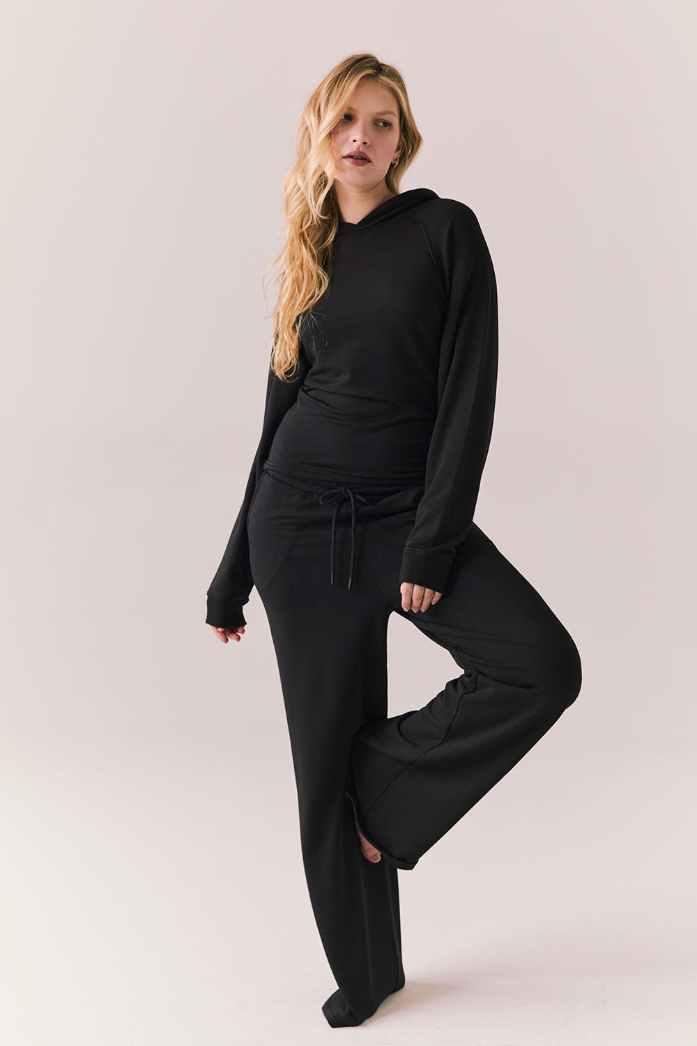 Model wearing black Sandyy trousers styled with matching pullover for full lounge set look.