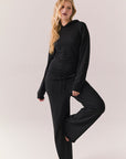 Model wearing black Sandyy trousers styled with matching pullover for full lounge set look.