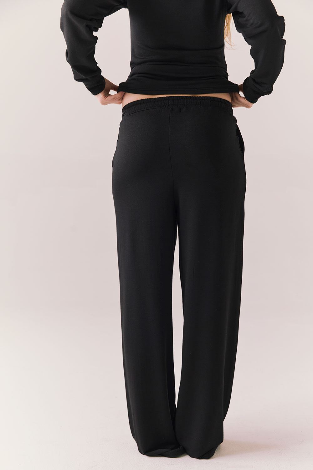 Back of black lounge pants with clean design and flowy silhouette.