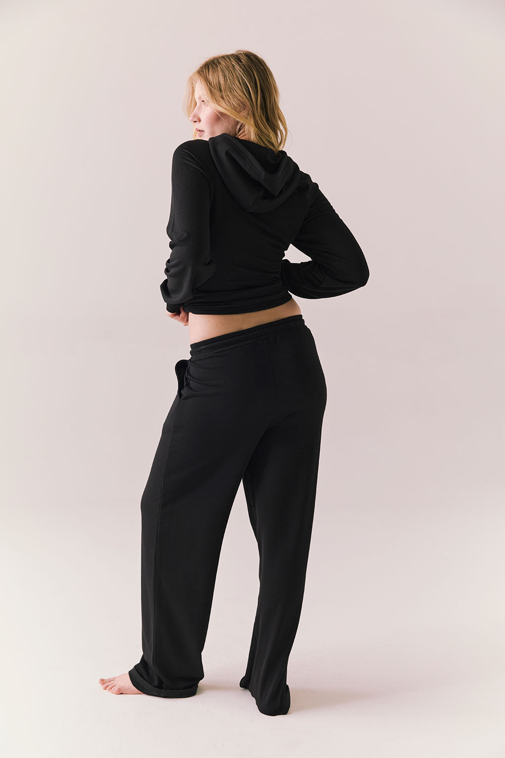 Model wearing black Sandyy trousers styled with matching pullover for full back lounge set look.
