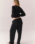Model wearing black Sandyy trousers styled with matching pullover for full back lounge set look.