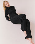 Model wearing black Sandyy trousers styled with matching pullover for full lounge set look.