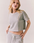 3/4 view of model in Irvine Tee in heather grey with soft thermal texture against a plain background