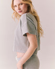 Side view of model in Irvine Tee in heather grey with soft thermal texture against a plain background