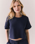Front view of model in Irvine Tee in midnight blue with soft thermal texture on plain background