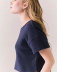 Side view of model in Irvine Tee in midnight blue with soft thermal texture on plain background