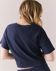 Back view of model in Irvine Tee in midnight blue with soft thermal texture on plain background
