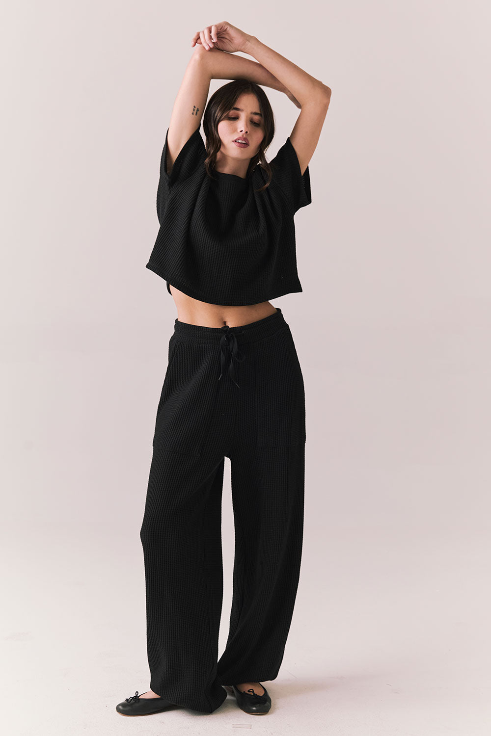 Full front view of model in Irvine Tee in true black with soft thermal texture and matching Billy Joggers