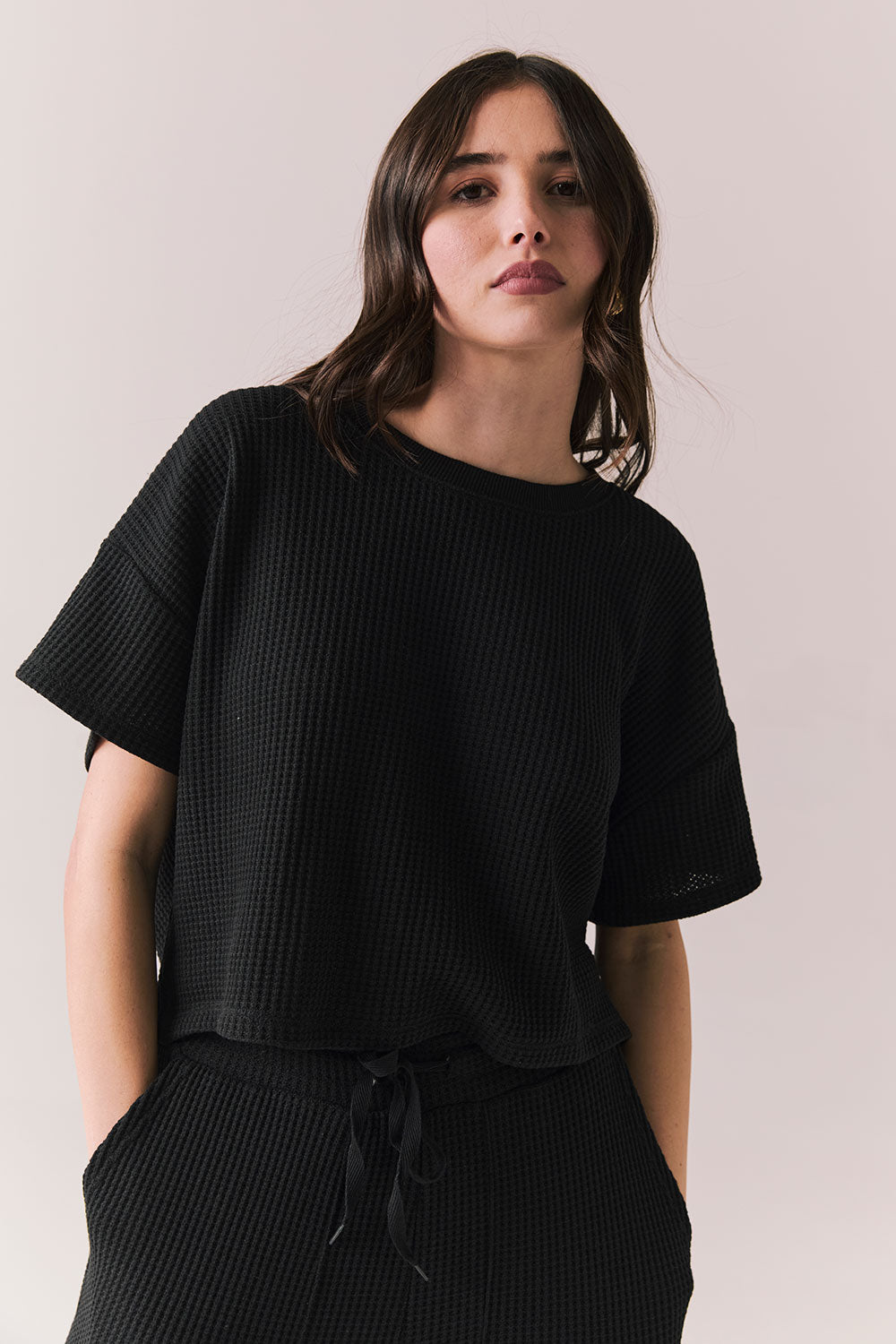 Front view of model in Irvine Tee in true black with soft thermal texture on plain background