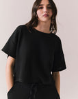 Front view of model in Irvine Tee in true black with soft thermal texture on plain background