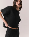 Side view of model in Irvine Tee in true black with soft thermal texture on plain background