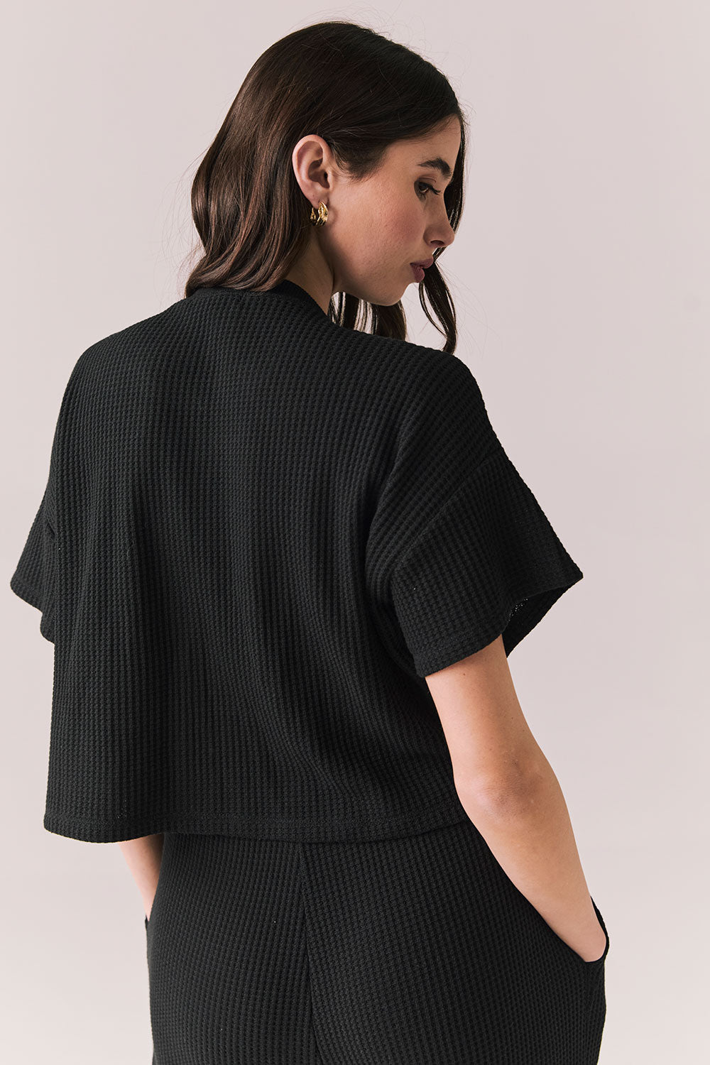 Back view of model in Irvine Tee in true black with soft thermal texture on plain background