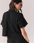 Back view of model in Irvine Tee in true black with soft thermal texture on plain background