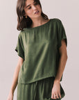Woman wearing the Davis tee in bronze green against a plain background