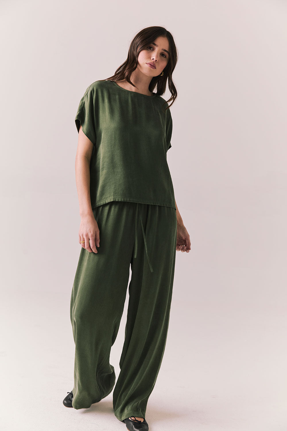 Full body view of women wearing the Davis Bronze Green green tee and matching Lee Pants on a white background