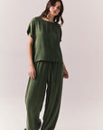 Full body view of women wearing the Davis Bronze Green green tee and matching Lee Pants on a white background