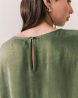 Back view of woman wearing the Davis tee in bronze green with matching Lee trousers, shot on a white background.