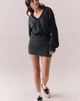 Full body view of model wearing Channel Mini Dress in silky true black