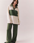 Woman wearing the color-blocked Chico Long Sleeve White and Green Rib Pullover and green pants on a white background