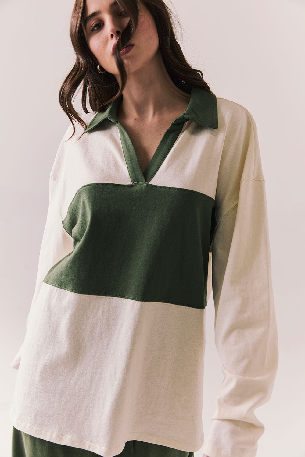 Woman wearing the color-blocked Chico Long Sleeve White and Green Rib Pullover on a white background