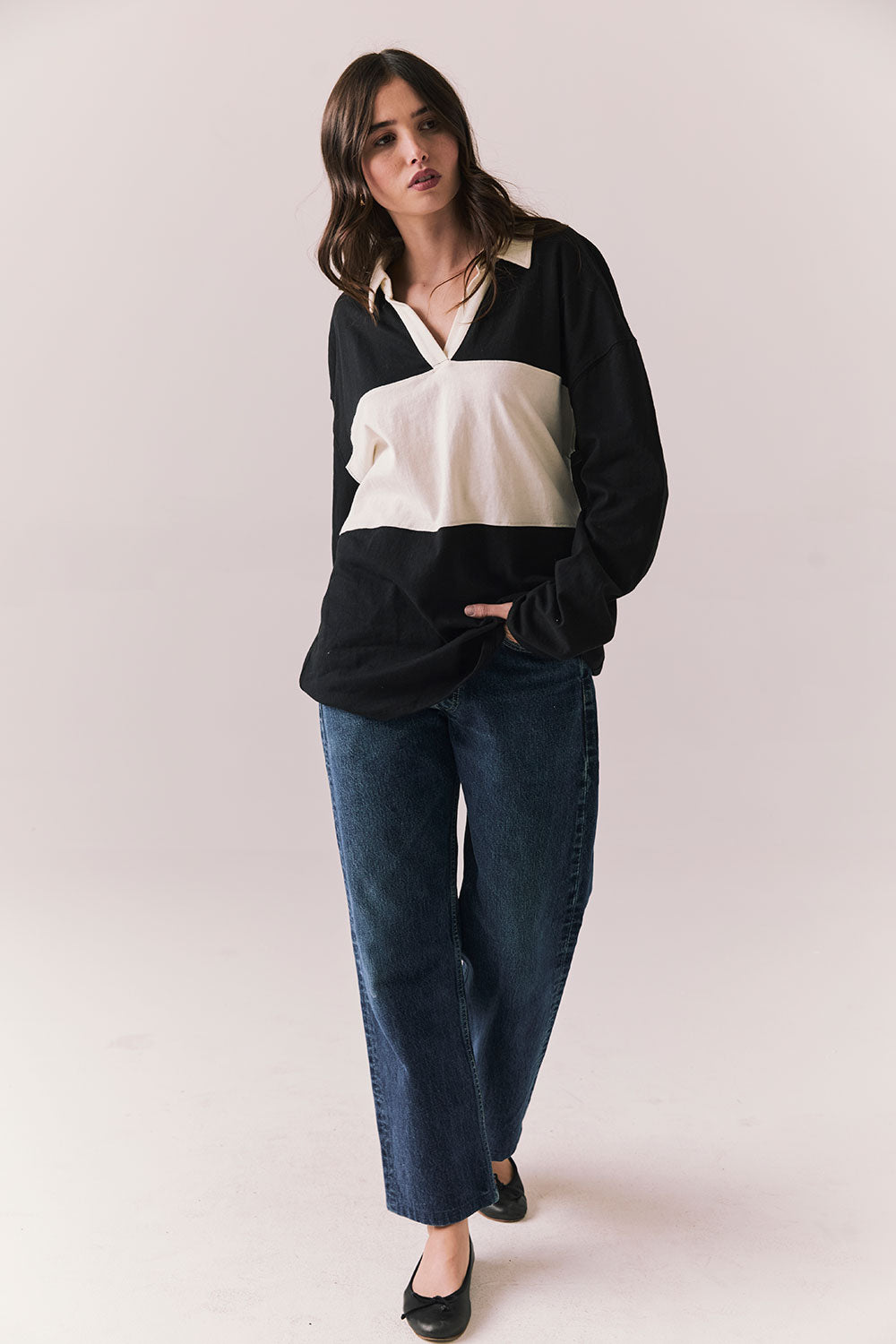 Full view of woman wearing a black and white Chico long sleeve with striped design against a plain background