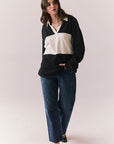 Full view of woman wearing a black and white Chico long sleeve with striped design against a plain background