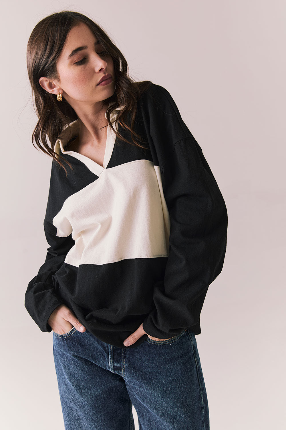 Side view of woman wearing a black and white Chico long sleeve with striped design against a plain background