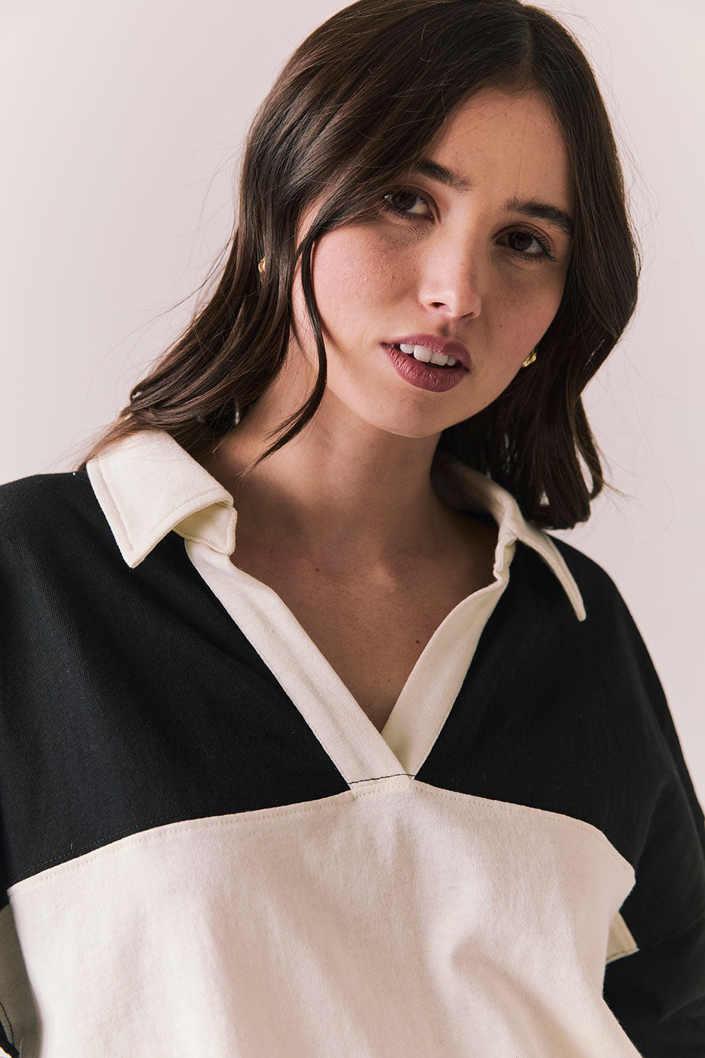 Front view of woman wearing a black and white Chico long sleeve with striped design against a plain background
