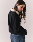 Back view of woman wearing a black and white Chico long sleeve with striped design against a plain background