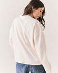 Back view of model wearing the Humboldt long sleeve in white with subtle star print and soft cotton texture and blue jeans against a white background