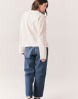 Full back view of model wearing the Humboldt long sleeve in starry white with soft cotton texture and blue jeans against a white background