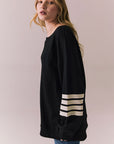 Side view of Pomona Long Sleeve in black and white with bold stripes and gigot sleeves against a plain background