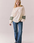 Full front view of Pomona long sleeve in Starry White with Bronze Green stripes and gigot sleeves with blue denim against a plain background