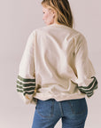 Back view of Pomona long sleeve in Starry White with Bronze Green stripes and gigot sleeves against a plain background