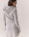Back view of model wearing Merced Hoodie Dress in Heather Grey with hood and thermal knit texture against a plain background