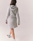 Full back view of model wearing Merced Hoodie Dress in Heather Grey with hood and thermal knit texture against a plain background