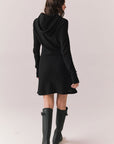 Back full body view of model in Merced Hoodie Dress in True Black with hood against a plain background