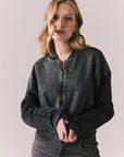 Front view of Fullerton hoodie in True Black with oversized silhouette with black jeans on a plain background