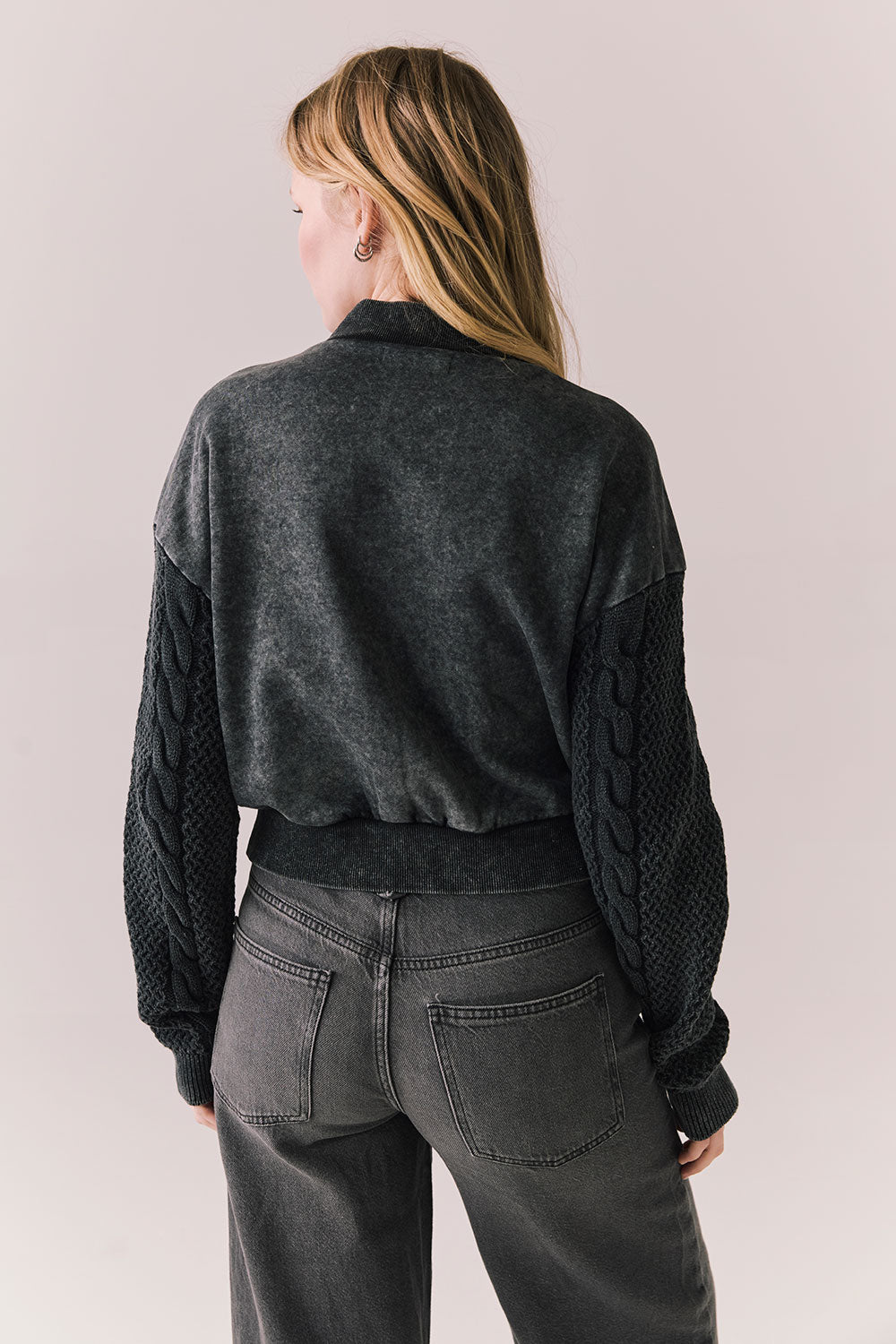 Back view of Fullerton hoodie in True Black with oversized silhouette with black jeans on a plain background