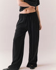 Front view of model wearing Lee Trouser in True Black with high-rise fit and wide-leg silhouette with matching Davis top against a plain background