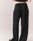Back view of model wearing Lee Trouser in True Black with high-rise fit and wide-leg silhouette with matching Davis top against a plain background