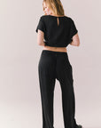 Full back view of model wearing Lee Trouser in True Black with high-rise fit and wide-leg silhouette with matching Davis top against a plain background