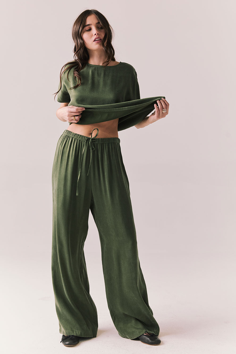 Full front view of Lee Trouser in bronze green with wide-leg silhouette and relaxed drape with matching tee against a plain background