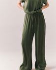 Front view of Lee Trouser in bronze green with wide-leg silhouette and relaxed drape against a plain background