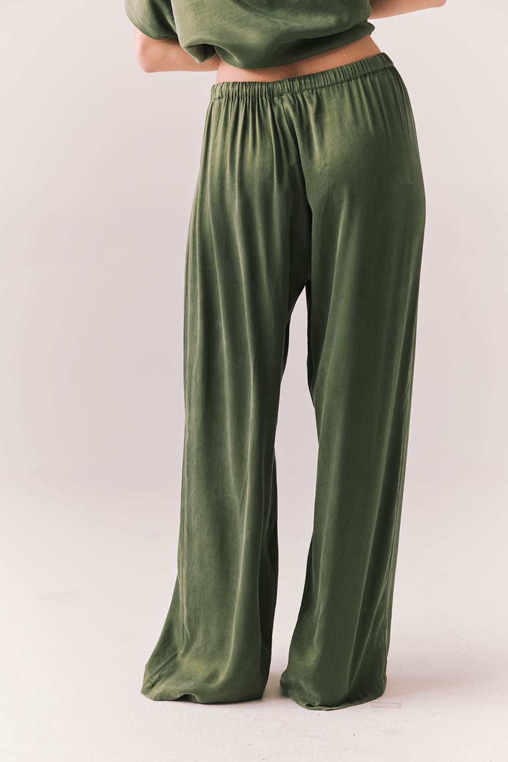 Back view of Lee Trouser in bronze green with wide-leg silhouette and relaxed drape against a plain background