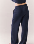 Back view of model wearing Billyy Joggers in midnight blue