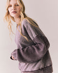 Side view of Maritime Pullover in fig (deep purple) with relaxed fit and knit texture against a plain background
