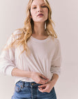 Front view of women wearing the Hartt long sleeve in white with cotton texture and clean silhouette and blue jeans against a plain background