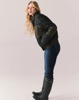 Full body angled pose of Chaser Brand Whistler Leopard and True Black Puffer Jacket styled with jeans and rain boots